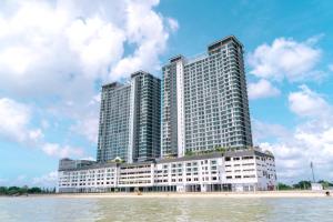 a large building on the water next to a body of water at Swiss-Belhotel Kuantan in Kuantan
