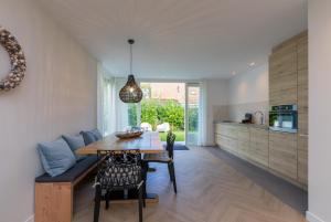 een keuken en eetkamer met een tafel en een bank bij Welcome in - Oosterpark 76 - Oostkapelle in Oostkapelle