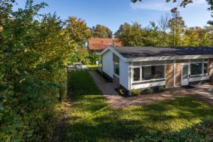 een klein huis met een grijs dak op een erf bij Welcome in - Oosterpark 76 - Oostkapelle in Oostkapelle