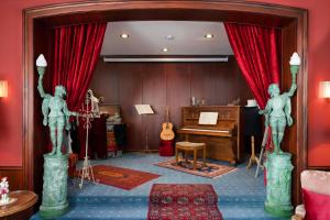 a room with a piano and two statues in it at Hotel bei Tante ALMA in Mannheim