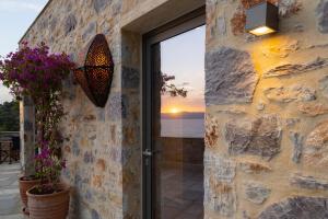 a stone wall with a door with a view of the ocean at Kechria Bay Villas in Skiathos