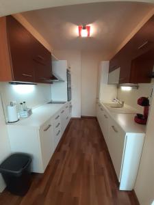 a small kitchen with white cabinets and wooden floors at Statevi Guest Apartment in Velingrad