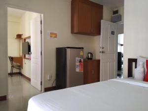 a bedroom with a white bed and a refrigerator at ฐิติกร แกรนด์วิว in Ban Talat Rangsit