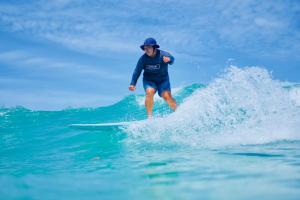 a man riding a wave on a surfboard in the ocean at Karon Sea Side in Karon Beach