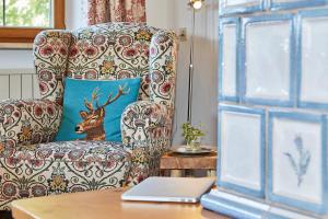 a chair with a blue pillow and a laptop on a table at Haus Waldeck in Reit im Winkl