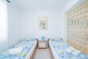 two twin beds in a small room with at Apartments Paco in Postira