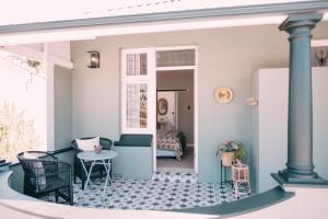 a home with a porch with a table and chairs at Sixteen On Latimer in East London