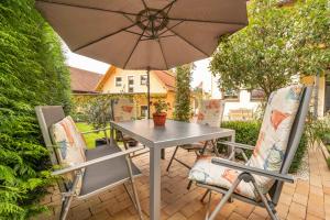 a table and chairs with an umbrella on a patio at Gaestezimmer Klein in Heiligenstadt