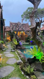 un jardín con piscina y una casa en Villa Telaga Wana en Sukawati