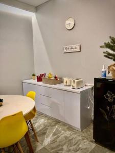 a kitchen with a table and a clock on the wall at Villa BSD City by REQhome in Ciater-hilir