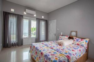 a bedroom with a bed and a large window at Villa Palm Springs by REQhome in Ciater-hilir
