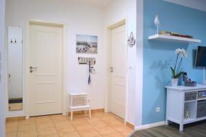 Zimmer mit zwei weißen Türen und einer blauen Wand in der Unterkunft Haus Sonnenhof Bansin in Bansin