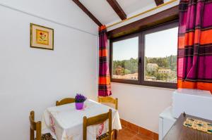 ein Esszimmer mit einem Tisch und einem Fenster in der Unterkunft Apartments & Rooms Mihajica in Cavtat