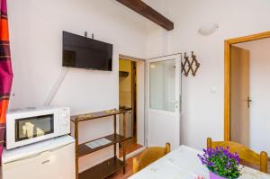 eine kleine Küche mit Tisch und Mikrowelle in der Unterkunft Apartments & Rooms Mihajica in Cavtat