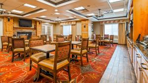 a conference room with tables and chairs and a television at Best Western Plus Canyon Pines in Ogden