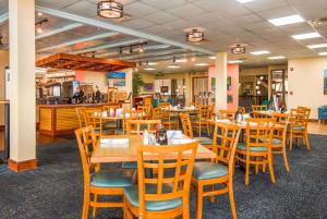ein Esszimmer mit Holztischen und Stühlen in der Unterkunft Ramada Plaza by Wyndham Nags Head Oceanfront in Kill Devil Hills
