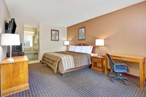 a hotel room with a bed and a desk with a computer at Days Inn by Wyndham Hernando in Hernando