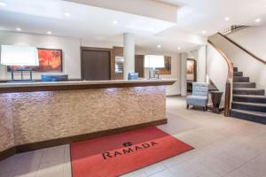 a hotel lobby with a reception counter and stairs at Ramada by Wyndham Kamloops in Kamloops