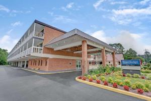 a large brick building with a sign in front of it at Travelodge by Wyndham Williamsburg Colonial Area in Williamsburg