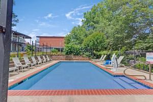 a large swimming pool with chairs at Travelodge by Wyndham Williamsburg Colonial Area in Williamsburg