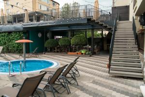 un patio con sillas, una piscina y escaleras en Guest House Venezia, en Anapa