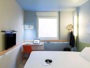 a bathroom with a sink, toilet and a window at ibis budget Zurich Airport in Glattbrugg