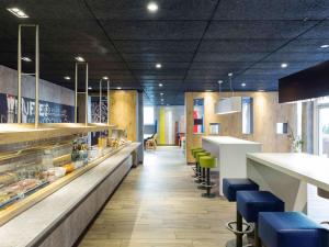 a kitchen filled with lots of tables and chairs at ibis budget Zurich Airport in Glattbrugg