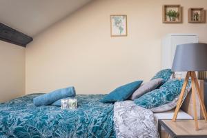 sypialnia z łóżkiem z niebieskimi poduszkami w obiekcie Bliss - GOLDEN TREE - WIFI - 20 min St-Croix & Center Parcs w mieście Sarrebourg