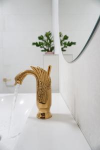 a bathroom sink with a gold faucet in a bathroom at Vibrant Design Apartments - Full Kitchen - Wi-Fi - 18 Mins to City Centre in Vienna
