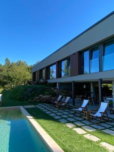 una casa con sillas y una piscina en Casa Maceira en Tomiño