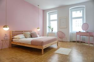 ein Schlafzimmer mit einem Bett und einer rosa Wand in der Unterkunft Vibrant Design Apartments - Full Kitchen - Wi-Fi - 18 Mins to City Centre in Wien