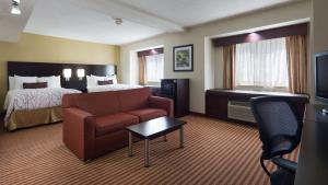 um quarto de hotel com um sofá e uma cama em Best Western Patriots Point em Charleston