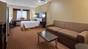 um quarto de hotel com uma cama e um sofá em Best Western Patriots Point em Charleston