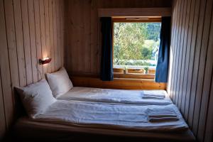 Cama en habitación con ventana en Hemsetunet Apartments en Hemsedal