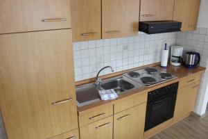 a kitchen with a sink and a stove at Haus Anker in Neuharlingersiel