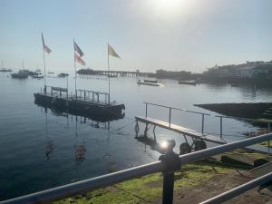a dock with two boats in the water with flags at Little Gem in Swanage