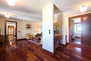uma sala de estar com pisos em madeira e uma sala com um piano em Hotel & SPA Monasterio de Boltaña em Boltaña