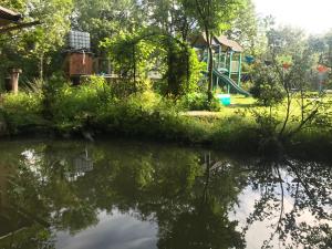 un parque con parque infantil y un estanque en Rest House 6A, en Obava