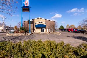 un edificio con un cartel en un estacionamiento en Motel 6-Eau Claire, WI, en Eau Claire