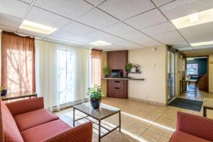 a living room with red chairs and a table at Motel 6-Eau Claire, WI in Eau Claire
