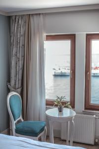 a bedroom with a bed and a table and a window at Hotel Limani in Çanakkale