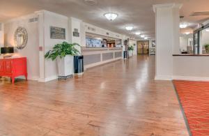 a large hallway with a hard wood floor in a building at Ramada by Wyndham Metairie New Orleans Airport in Metairie