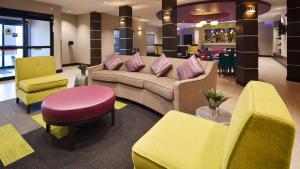een lobby met een bank en een tafel en stoelen bij Best Western Plus Prien Lake Hotel & Suites - Lake Charles in Lake Charles