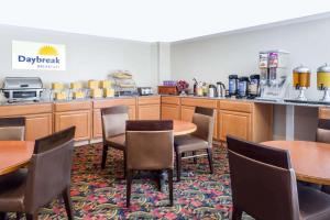 a dining room with tables and chairs and a kitchen at Days Inn by Wyndham Williamsburg Historic Area in Williamsburg