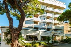 un edificio con un albero di fronte di Hotel Palma de Majorca a Bibione