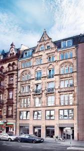 un gran edificio con coches estacionados frente a él en Five Elements Hostel Frankfurt, en Frankfurt