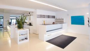 a white kitchen with a counter and a black rug at Stanys - Das Apartmenthotel in Vienna