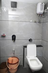 a bathroom with a toilet and a phone on the wall at Hotel Sai Neel in Surat