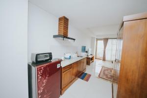 a kitchen with a red refrigerator and wooden cabinets at Apartemen Tera Residence in Bandung