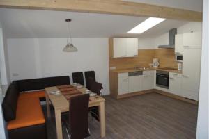 a kitchen and a dining room with a table and chairs at Gertis Appartment Top 2 in Stumm